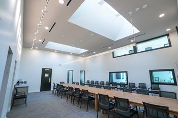 A conference room with a long table and chairs.
